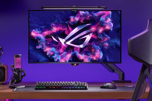 An image showing the ASUS ROG Swift PG32UCDM monitor mounted on a stand that's attached to a gaming desk.