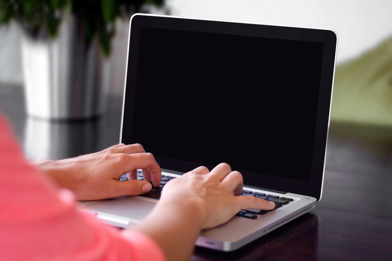 Person working on laptop with black screen