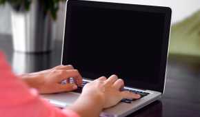 Person working on laptop with black screen
