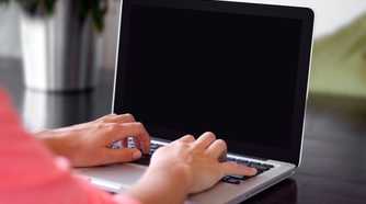 Person working on laptop with black screen