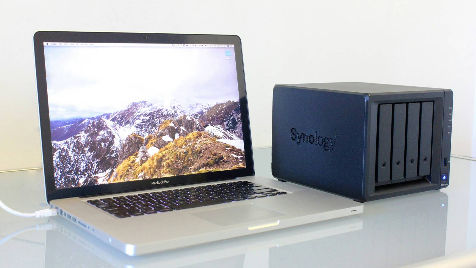 Photo of a MacBook Pro connected to a Synology NAS.