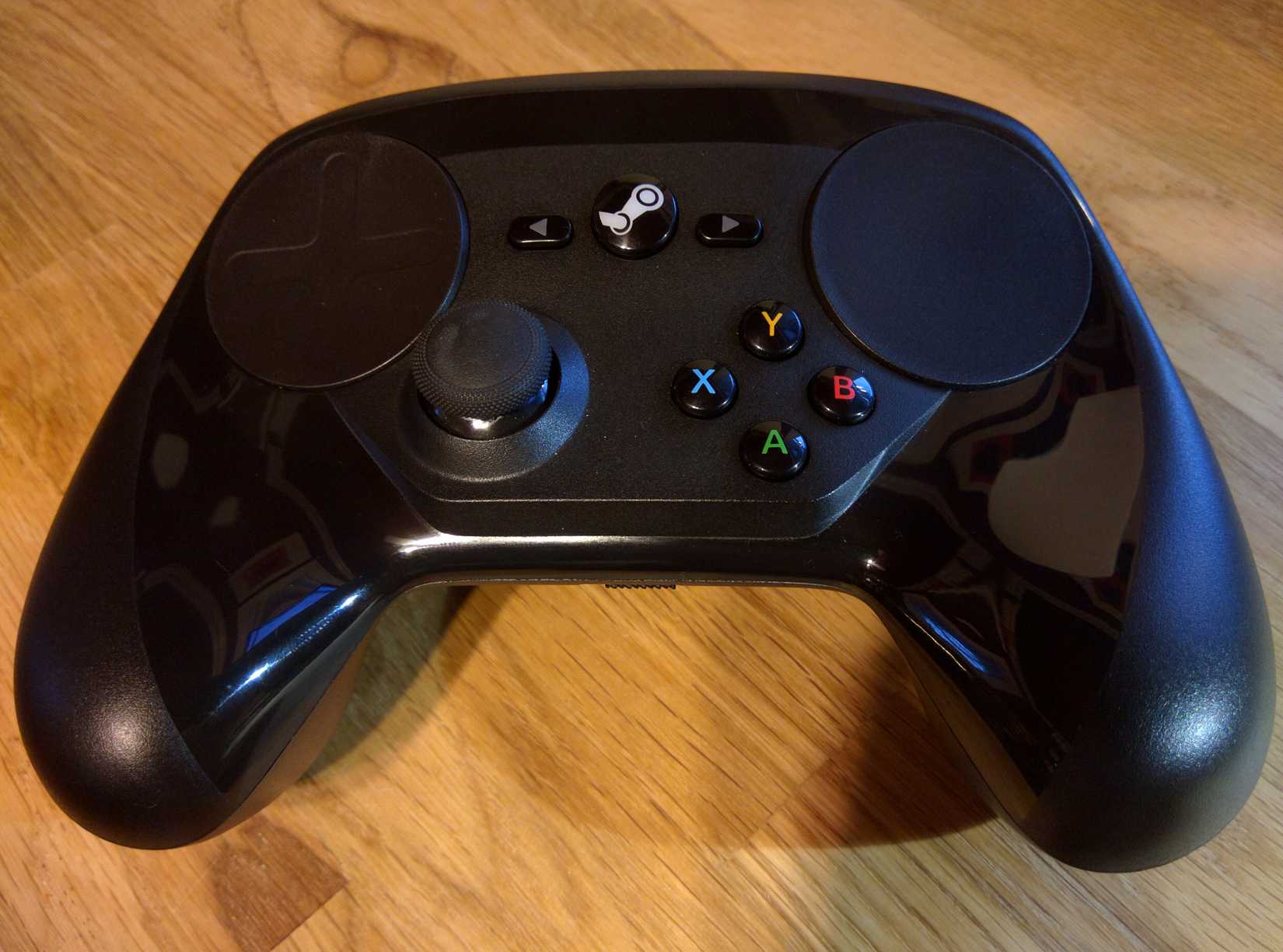 A Steam Controller placed on a wooden surface.
