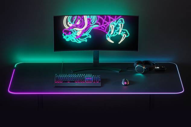 A monitor, SteelSeries keyboard, mouse, and headset on top of SteelSeries QCK Prism RGB mousepad