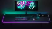 A monitor, SteelSeries keyboard, mouse, and headset on top of SteelSeries QCK Prism RGB mousepad