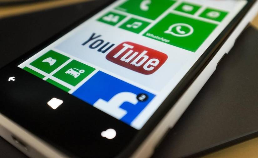 Close-up of a Windows phone with the YouTube app pinned to the Start screen