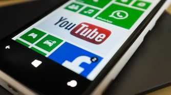 Close-up of a Windows phone with the YouTube app pinned to the Start screen