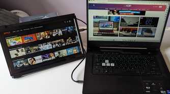 portable monitor showing netflix while laptop shows XDA website