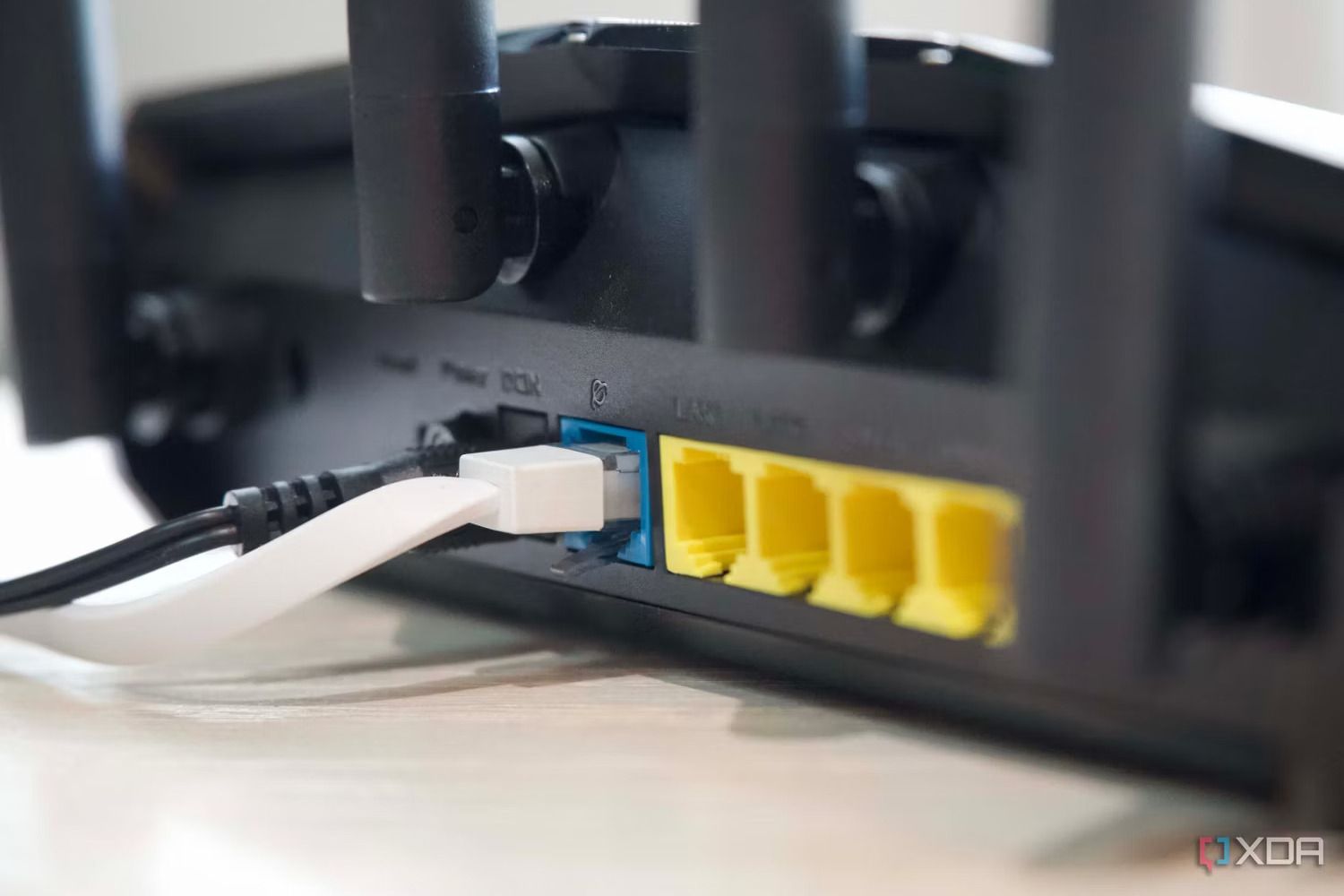 Puertos Ethernet y antenas del Asus RT-AX57 desde un ángulo