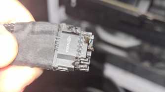 An image showing a person holding a burnt 12VHPWR connector in their hand.