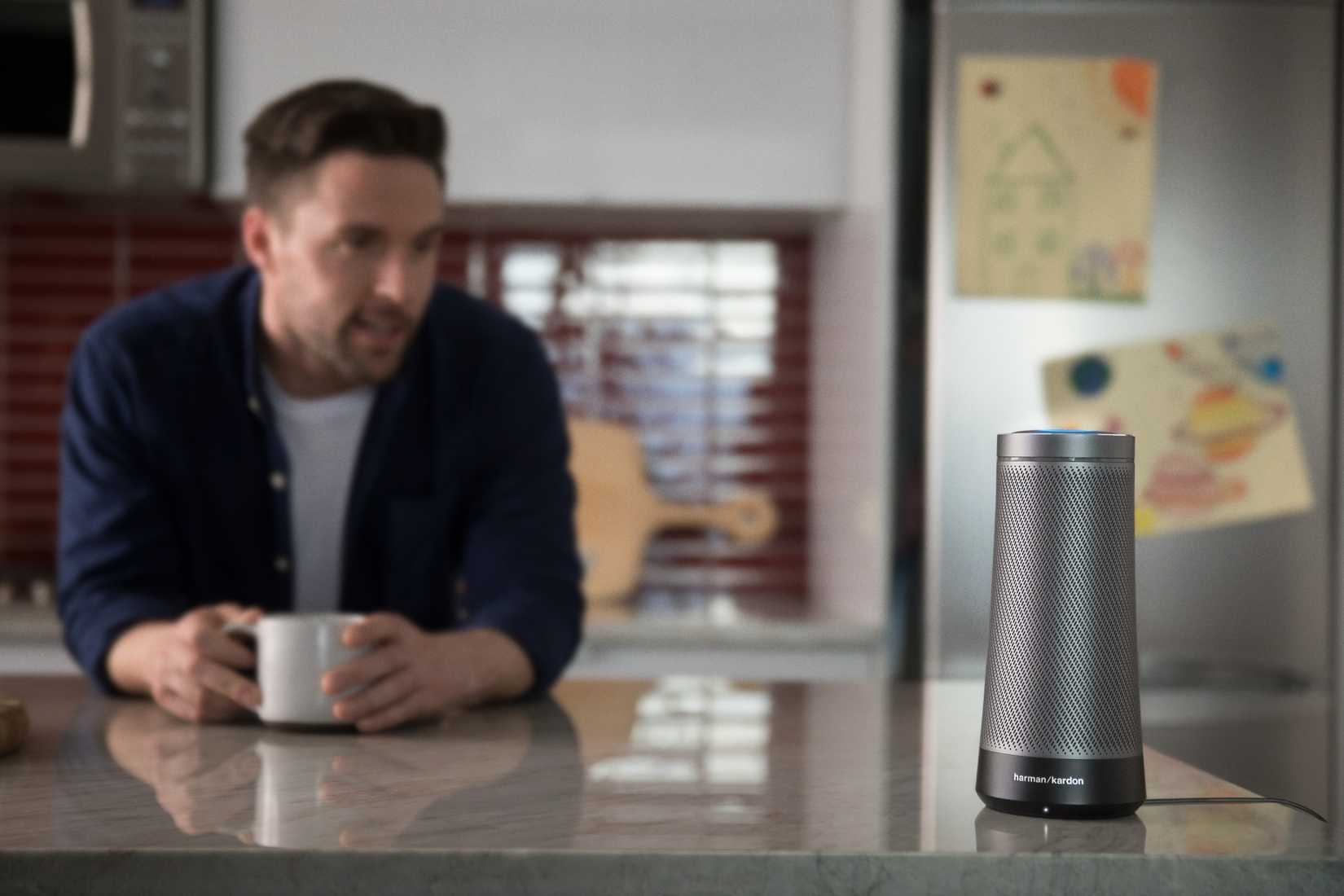 A person sitting near a Harman Kardon Invoke speaker