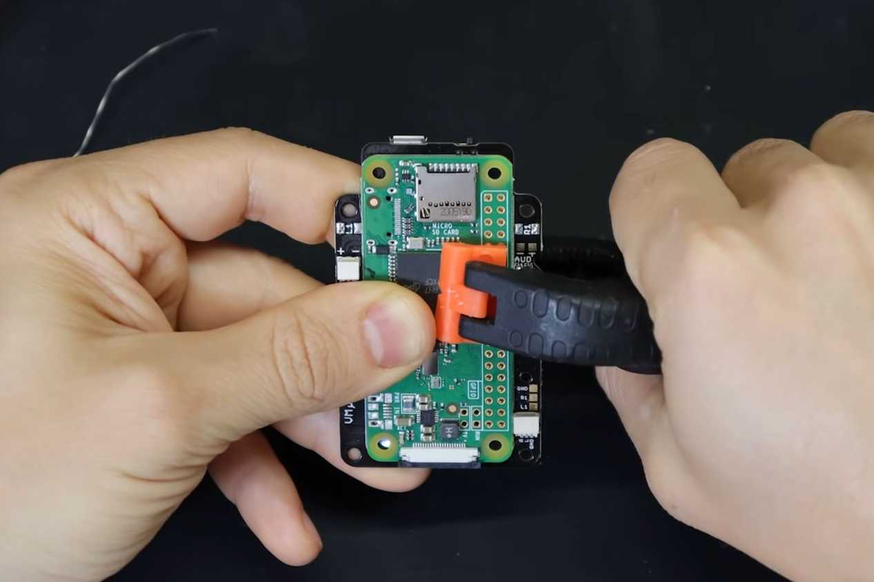 An image showing a person attaching a Raspberry Pi module to a PCB.