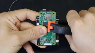 An image showing a person attaching a Raspberry Pi module to a PCB.