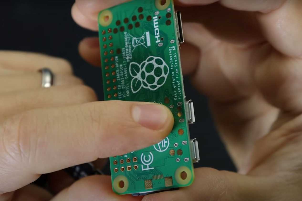 An image showing a person pointing the ports on the Raspberry Pi.