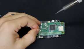 A screenshot showing a person soldering a Raspberry Pi module to onto a PCB.