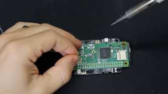 A screenshot showing a person soldering a Raspberry Pi module to onto a PCB.