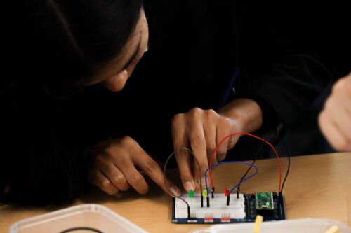 Una imagen de un estudiante usando una Raspberry Pi Pico en un aula.