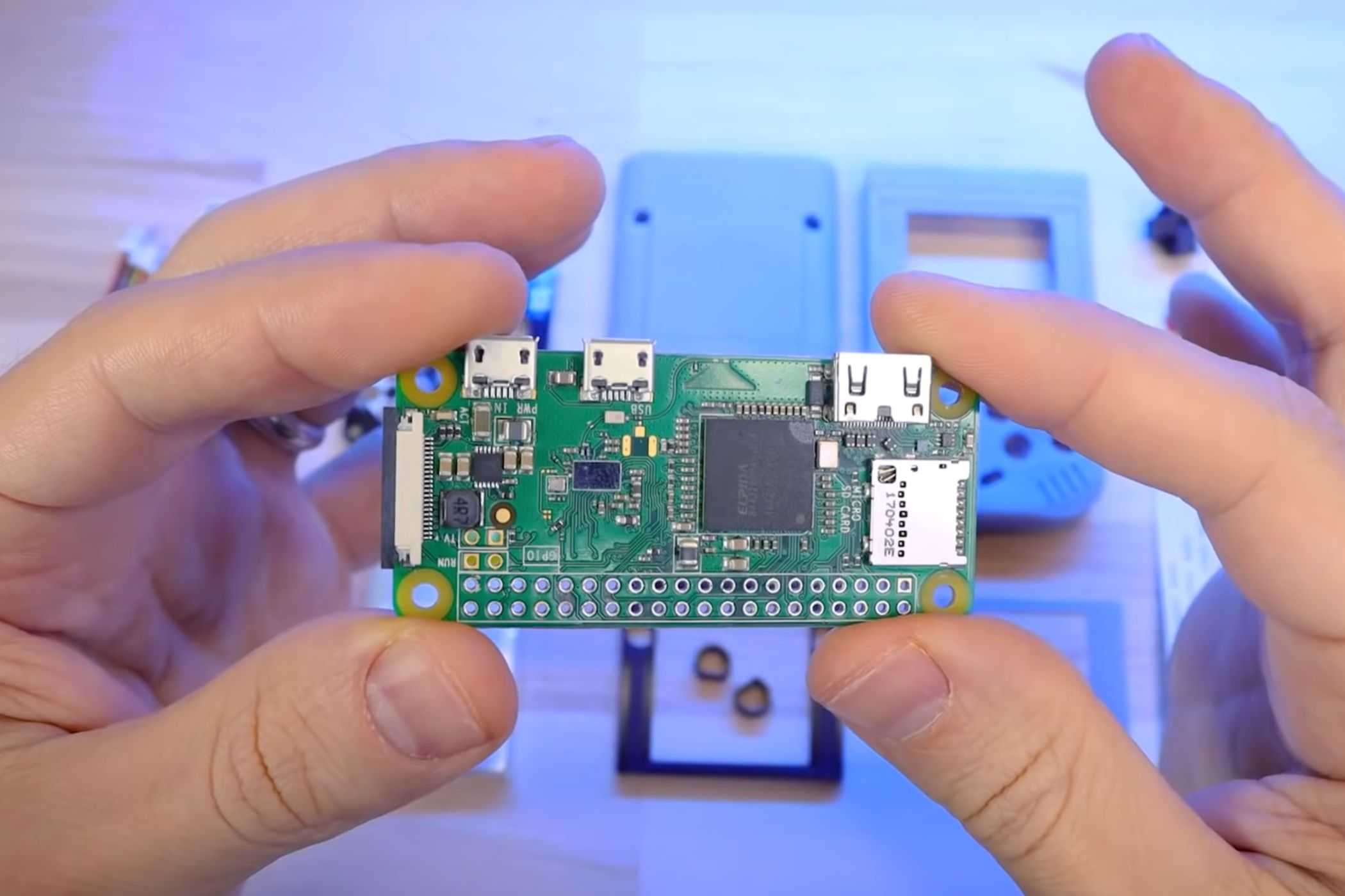 An image showing a person holding a Raspberry Pi module in their hand.