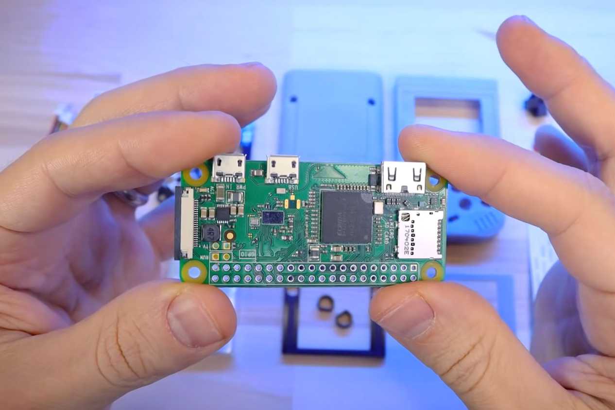 An image showing a person holding a Raspberry Pi module in their hand.