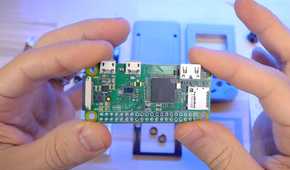 An image showing a person holding a Raspberry Pi module in their hand.