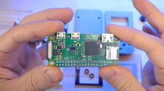 An image showing a person holding a Raspberry Pi module in their hand.