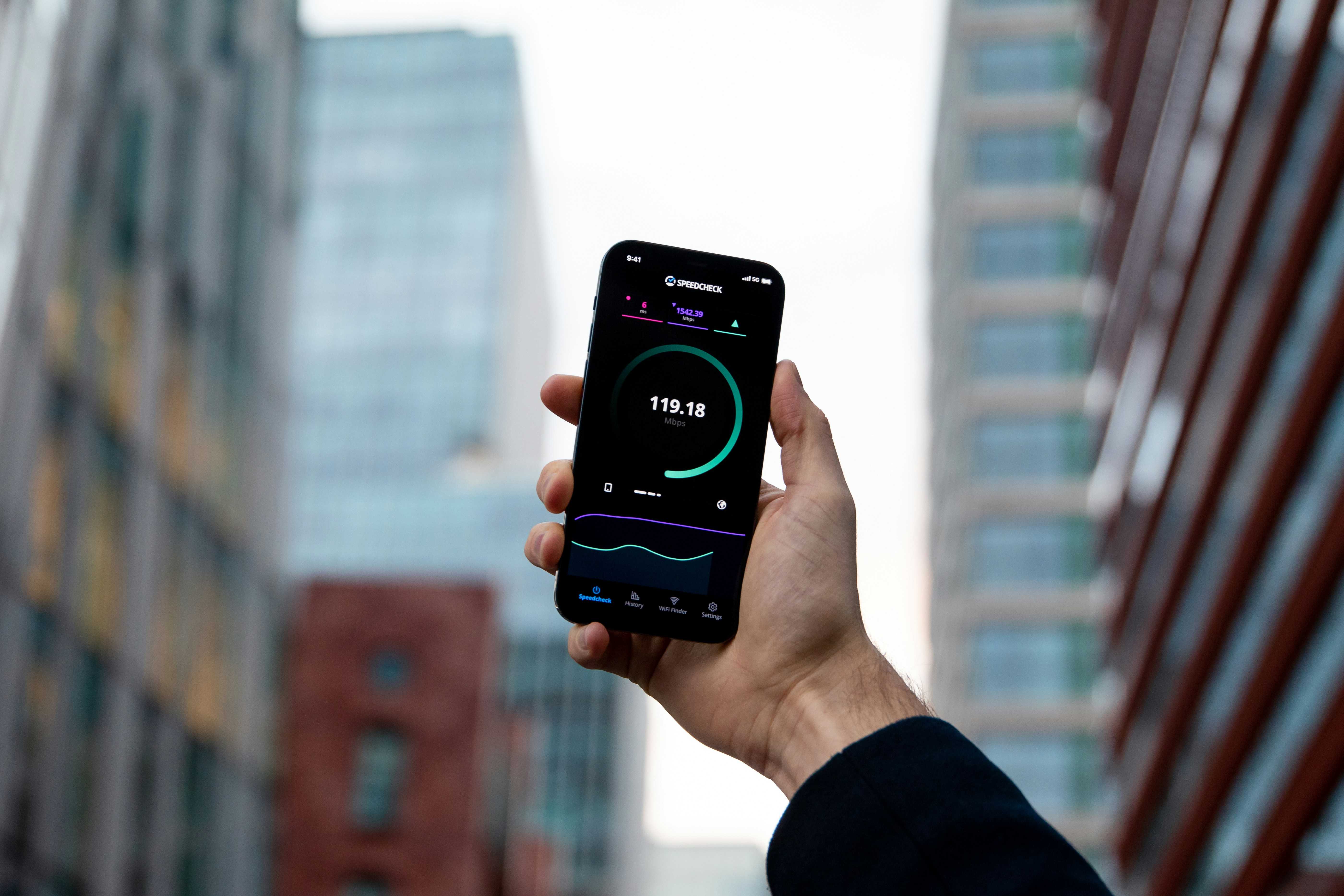 A photo of person holding a smartphone that runs a speedtest
