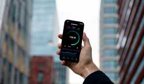 A photo of person holding a smartphone that runs a speedtest
