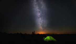 A green tend under a starry night sky