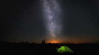 A green tend under a starry night sky