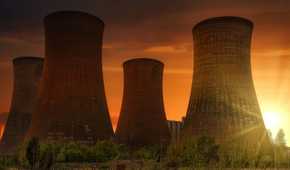 Wide shot of a nuclear power plant wityh four cooling towers