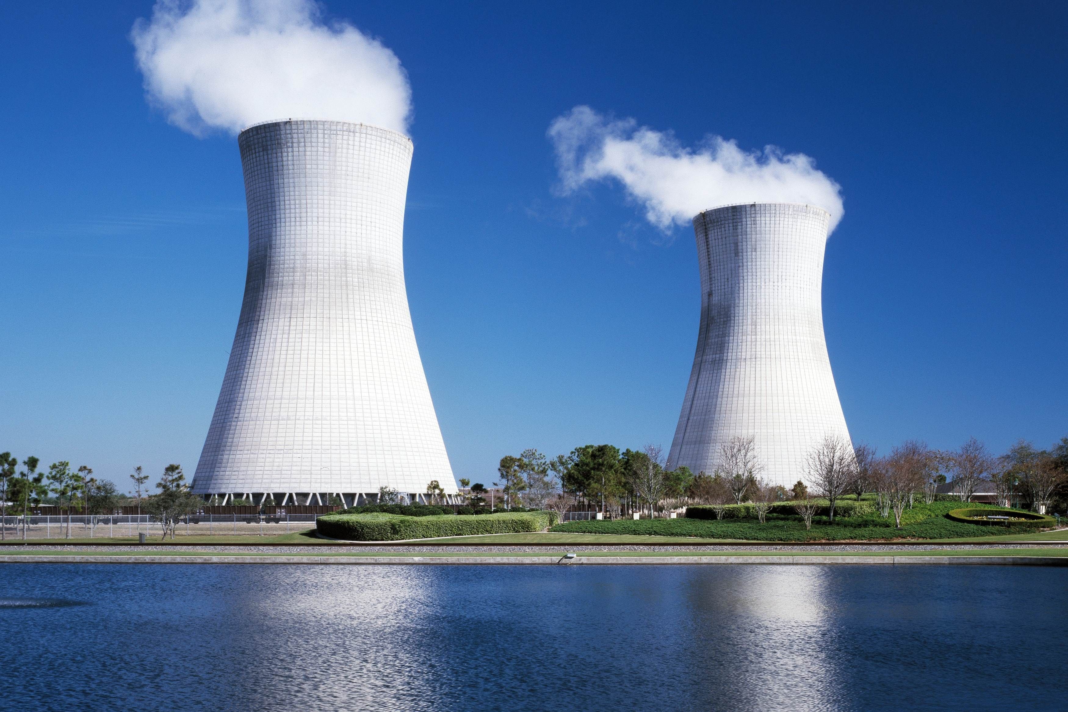 A nuclear power plant emitting smoke near a water body