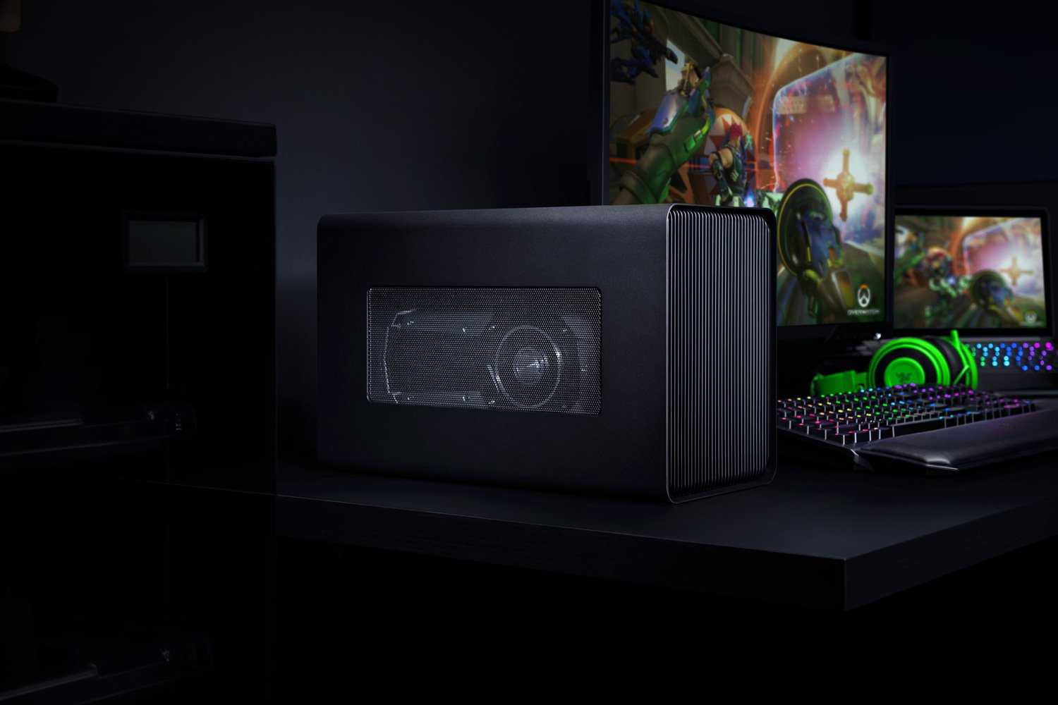 A Razer Core X Chroma in a gaming setup including a laptop, monitor, keyboard, and headphones