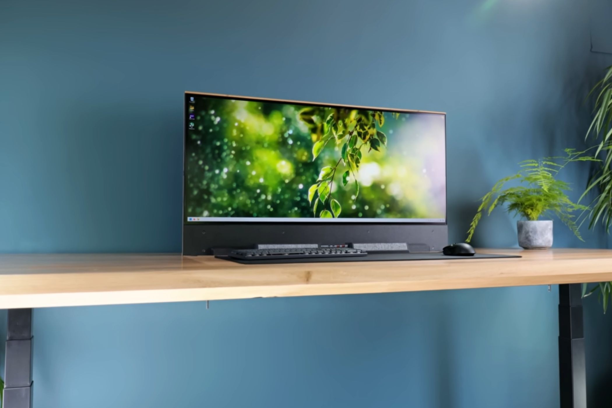 An image showing a monitor resting on a table with peripheral in front of it
