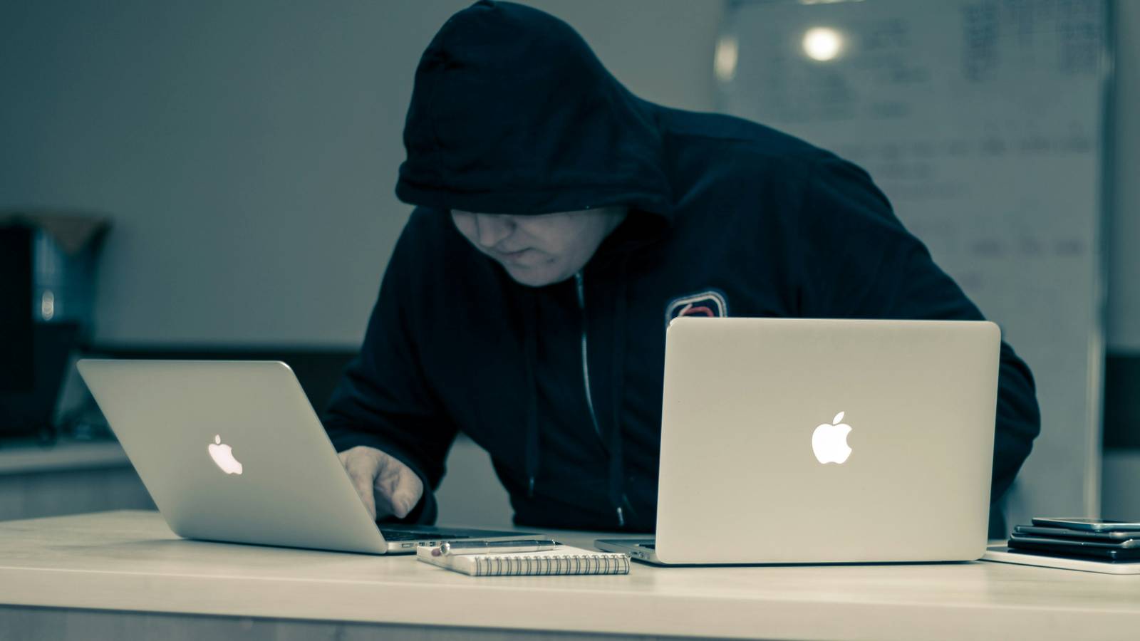 hacker typing on an Apple laptop
