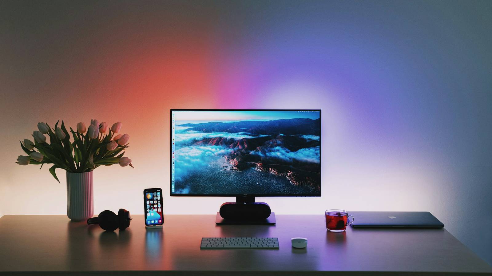 A PC desk setup with lighting behind the monitor