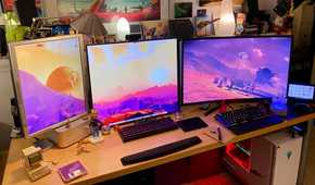 PC setup with multiple monitors and figurines on the desk