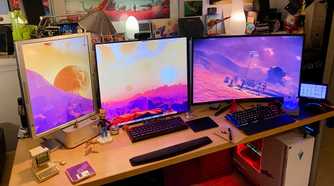 PC setup with multiple monitors and figurines on the desk
