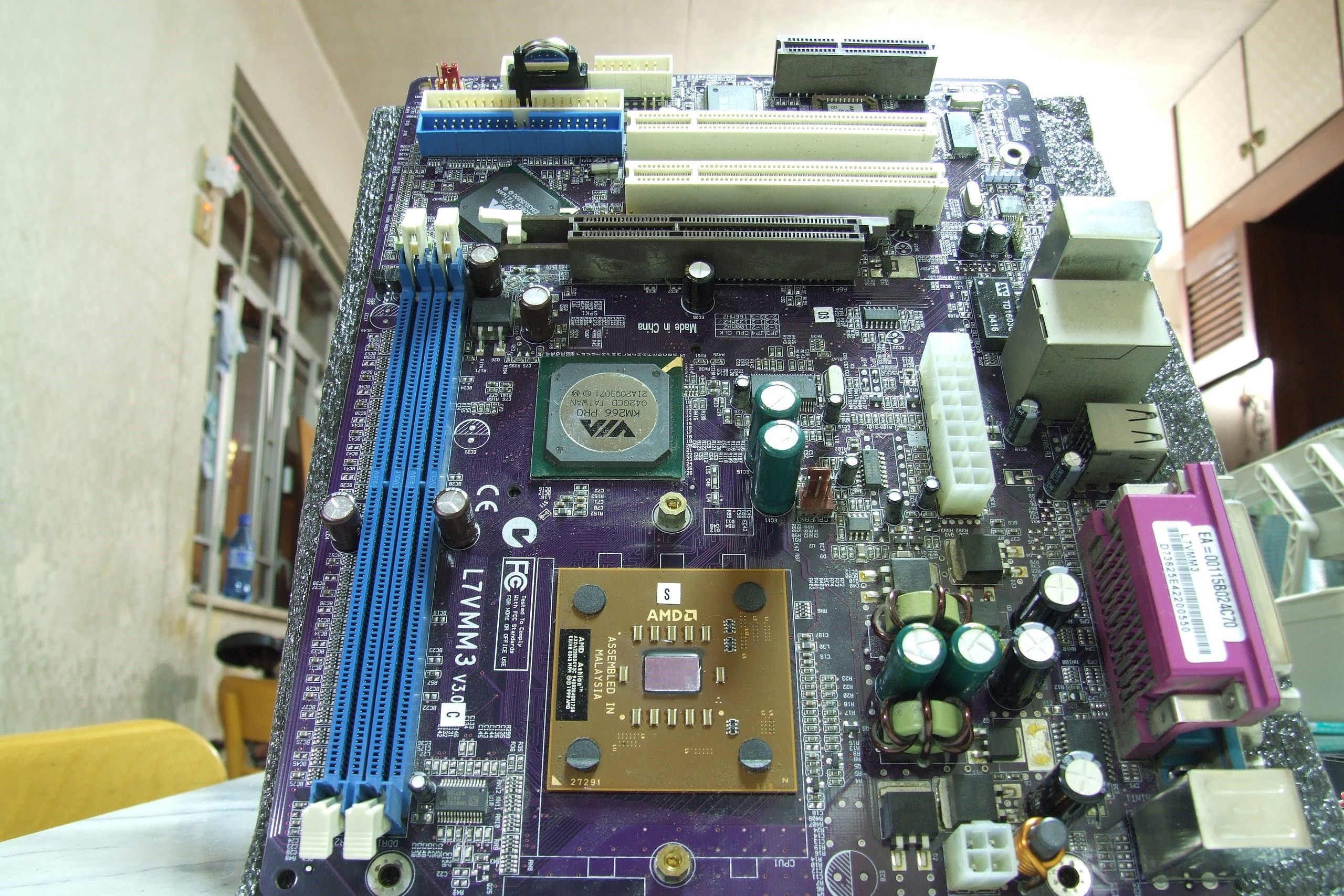 An ATX motherboard lying vertically on a white surface