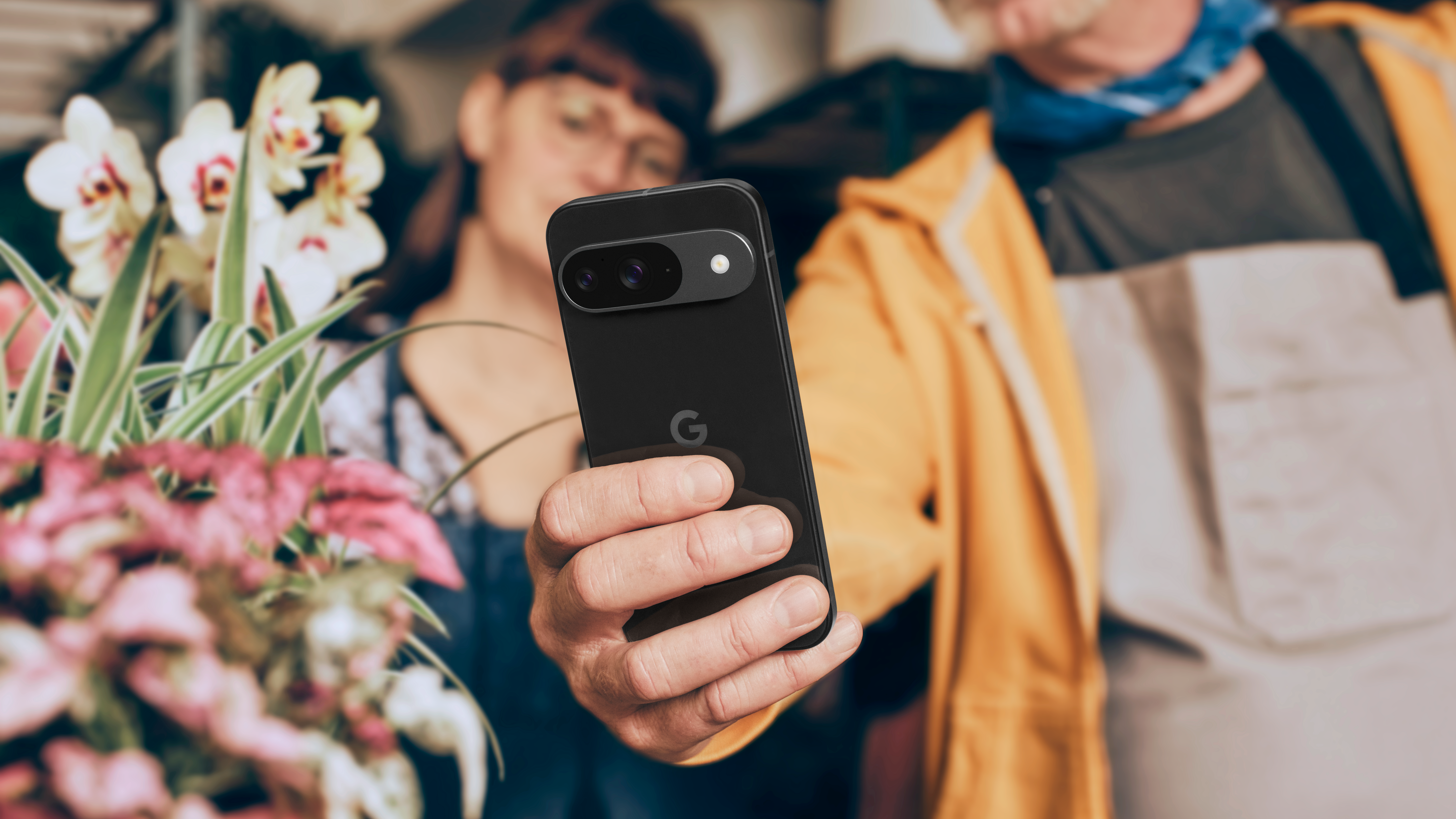 A man holding a Google Pixel 9 in the Obsidian colorway