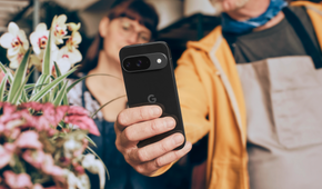 A man holding a Google Pixel 9 in the Obsidian colorway