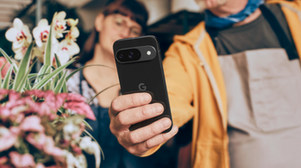 A man holding a Google Pixel 9 in the Obsidian colorway