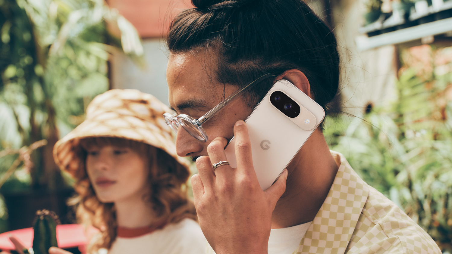 A man holding a Porcelain Google Pixel 9 up to his face for a call