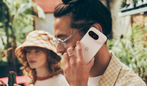A man holding a Porcelain Google Pixel 9 up to his face for a call