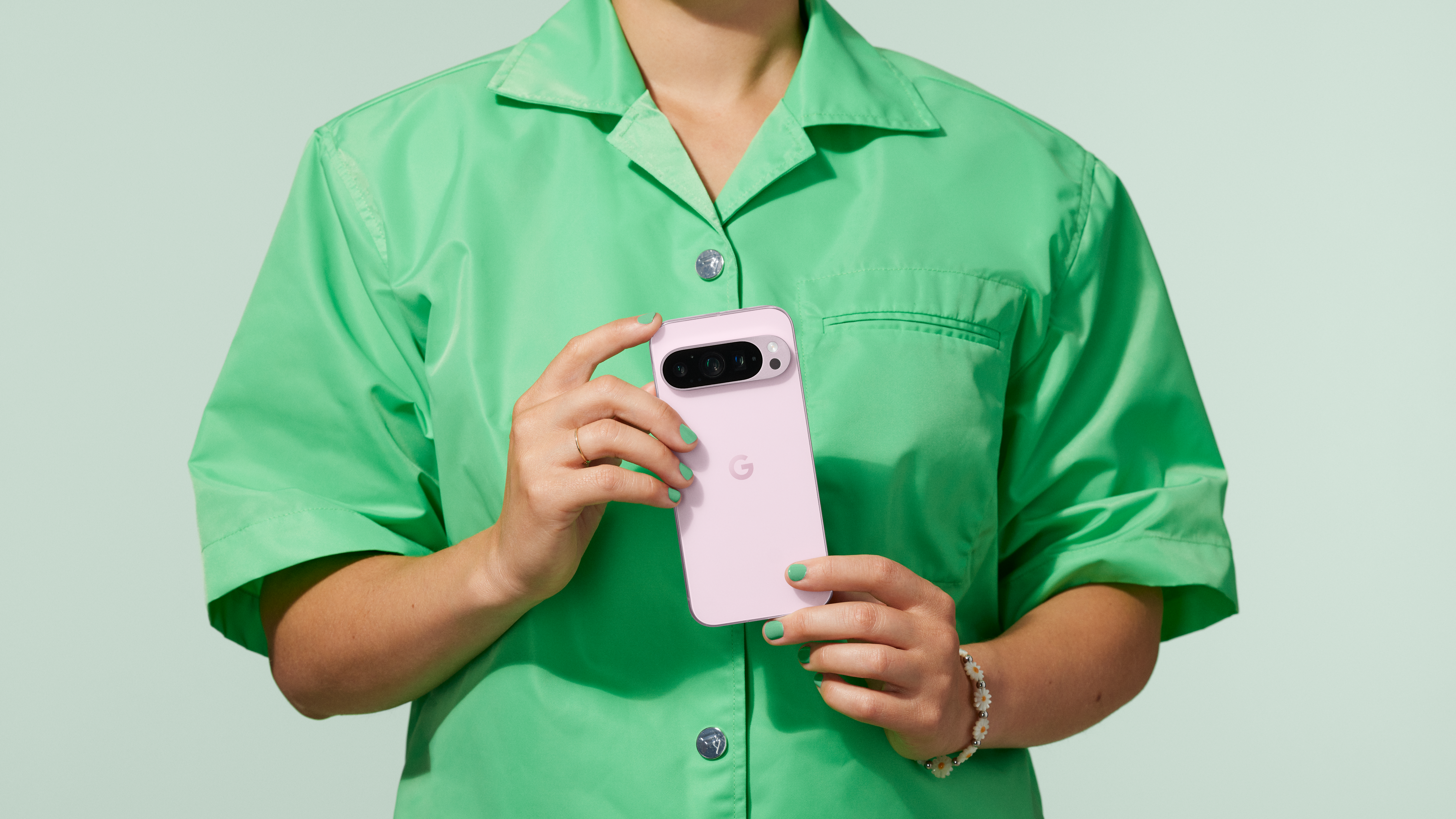 Woman holding a Rose Quartz Google Pixel 9 Pro in both hands showing the back of the phone
