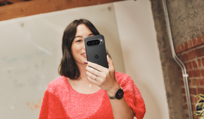 A woman holding an Obsidian Pixel 9 Pro in front of a mirror