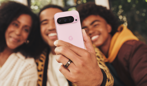 A man taking a group selfie using a Google Pixel 9 Pro in Rose Quartz