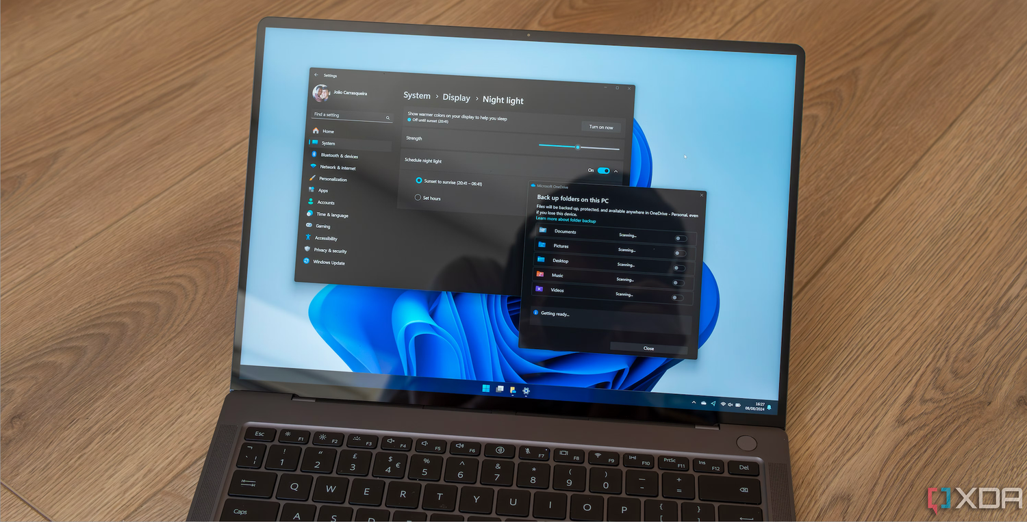 A Windows 11 laptop displaying the settings for night light and OneDrive backups