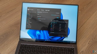 A Windows 11 laptop displaying the settings for night light and OneDrive backups
