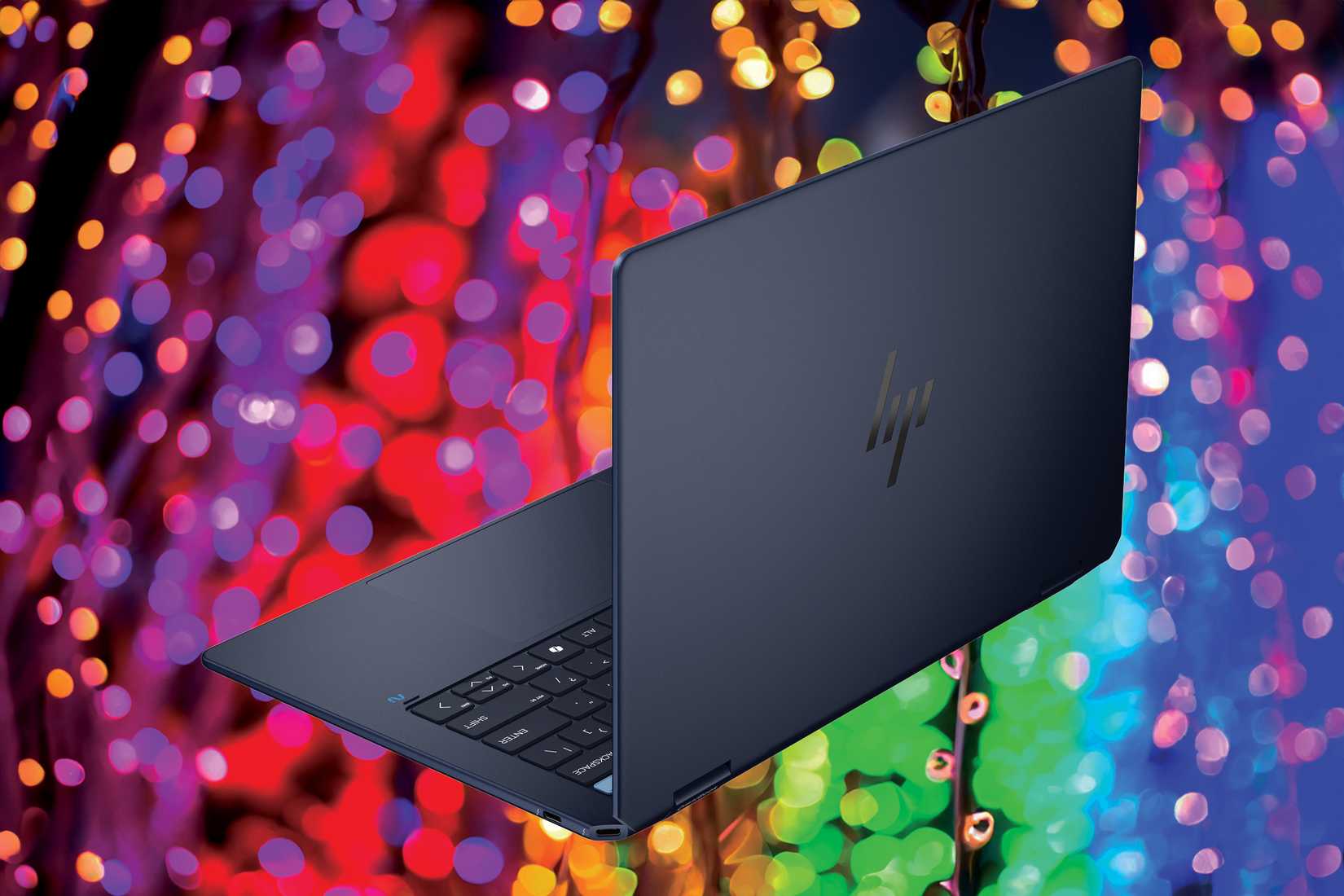 Angled rear view of the HP OmniBook Ultra Flip 14 over colored lights