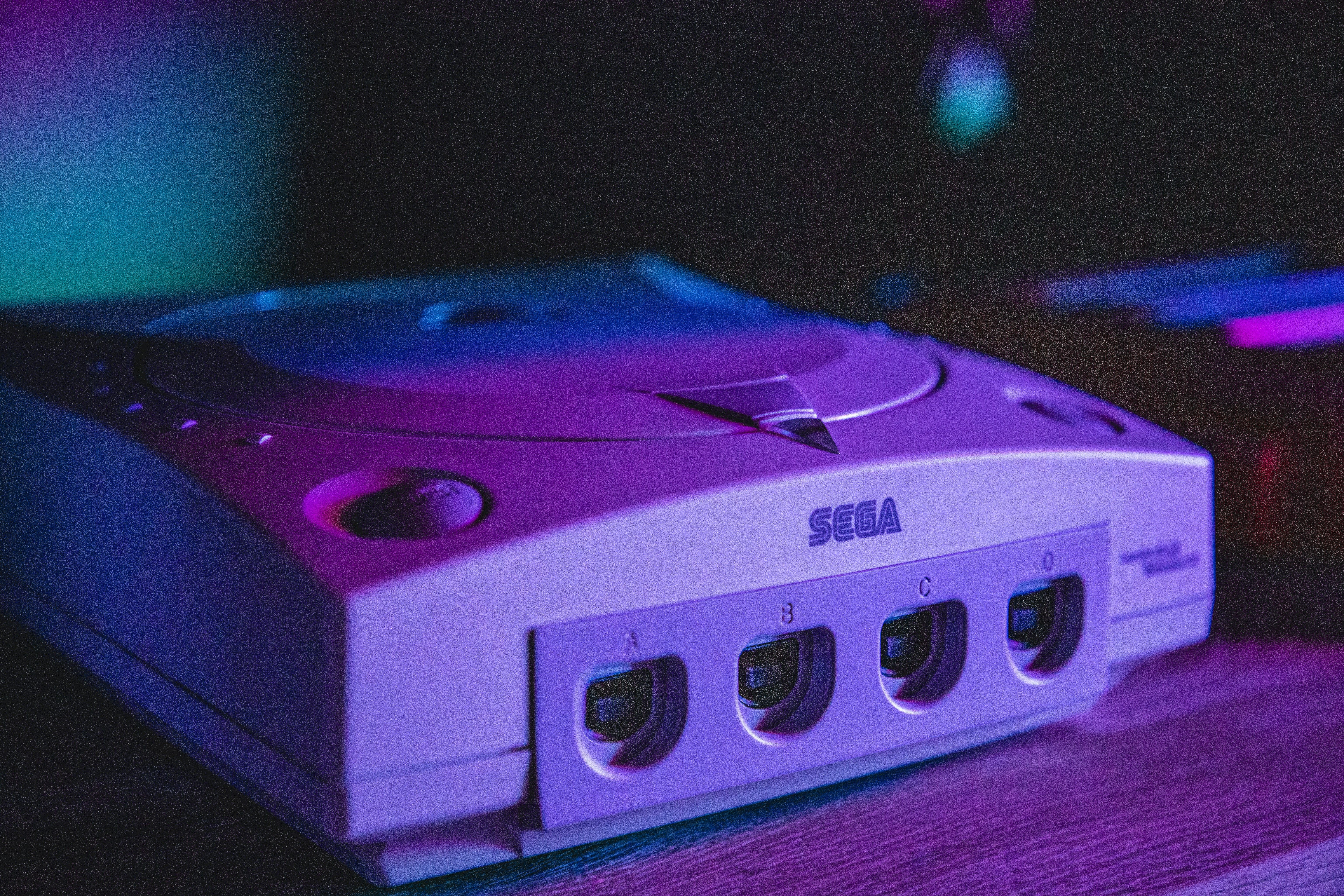 A Sega Dreamcast in moody purple lighting.