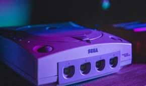 A Sega Dreamcast in moody purple lighting.